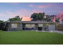 Charming single-story home with a well-manicured lawn, blue lawn chairs, and a serene neighborhood setting at 9948 51St N Ave, St Petersburg, FL 33708