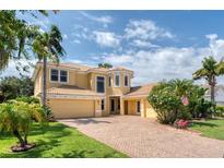 Stunning two-story home with a brick driveway, lush landscaping, and a warm, inviting facade at 12610 Eagles Entry Dr, Odessa, FL 33556