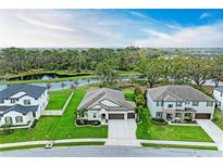 Stunning aerial view of a modern home with a lake view and well-manicured lawn at 13034 Bliss Loop, Bradenton, FL 34211