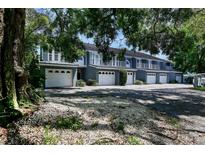 Beautiful townhome exterior with white garages and second story balconies surrounded by lush landscaping at 1506 S Bay Villa Pl # C, Tampa, FL 33629