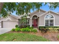 Charming single-story home with well-maintained landscaping, a red front door and neutral color palette at 16522 Ivy Lake Dr, Odessa, FL 33556