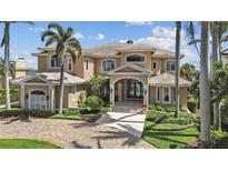 Stunning two-story home featuring a beautiful archway entryway, complemented by lush tropical landscaping and a brick driveway at 1737 Brightwaters Ne Blvd, St Petersburg, FL 33704