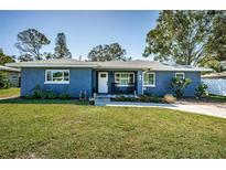 Charming one story home with a lush lawn, classic curb appeal and rocking chairs at 1965 Allard Dr, Clearwater, FL 33763