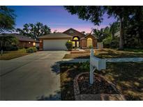 Charming single Gathering home exterior featuring a well-manicured lawn and a two-car garage at twilight at 2745 Buckhorn Preserve Blvd, Valrico, FL 33596