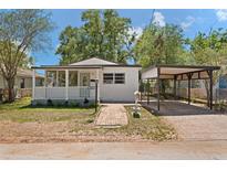 Charming single-story home with a screened porch, a carport and a brick walkway in a landscaped yard at 2821 Marconi St, Tampa, FL 33605