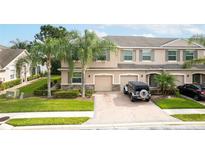 Inviting townhome featuring a paver driveway, attached garages, and manicured landscaping at 3844 Silverlake Way, Wesley Chapel, FL 33544