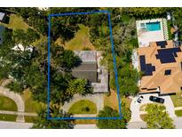 Aerial view showcasing the home surrounded by lush greenery and a well-maintained landscape at 459 Bayview Ne Dr, St Petersburg, FL 33704
