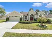 Charming home with a well-manicured lawn, lush landscaping, and a welcoming entrance at 4656 Copper Hill Dr, Spring Hill, FL 34609