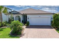 Charming single-Gathering home featuring lush landscaping, a paver driveway, and a welcoming covered porch at 5597 Bay Tide Ct, Land O Lakes, FL 34638