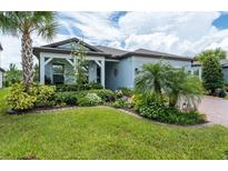 Charming home featuring lush landscaping, a well-manicured lawn, and a welcoming covered entryway at 5597 Bay Tide Ct, Land O Lakes, FL 34638