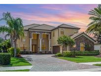 Stately two-story home with lush landscaping, brick driveway, and grand entrance with impressive columns at 5656 Cloverleaf Run, Bradenton, FL 34211