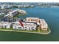 Aerial view of a waterfront condo with a parking lot and beautiful water views, perfect for coastal living at 7645 Sun Island S Dr # 304, South Pasadena, FL 33707