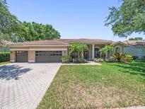Charming single-story home with a tile roof, three-car garage, and well-manicured lawn at 1084 Berkshire Ln, Tarpon Springs, FL 34688