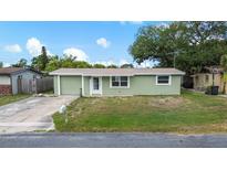 Charming one-story home with a well-maintained lawn and neutral-colored exterior under a clear blue sky at 2166 Dixie Garden Loop, Holiday, FL 34690