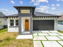 Charming single-story home featuring a modern architectural design and well-manicured lawn at 2305 W Kentucky Ave, Tampa, FL 33607