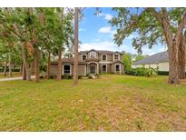 Stunning two-story home featuring a lush green lawn and mature trees for added privacy at 2512 Clubhouse Dr, Plant City, FL 33566