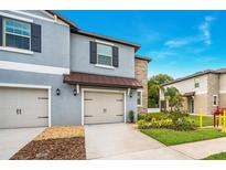 Charming townhome with a two-car garage, stone accents, and well-manicured landscaping at 30752 Veridian Way, Wesley Chapel, FL 33545