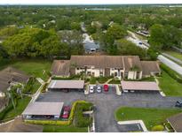 An aerial view of the condo community shows lush landscaping and convenient covered parking at 3540 Countrybrook Ln # 23, Palm Harbor, FL 34684