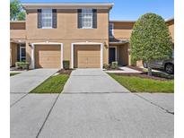 Inviting exterior of a two-story townhome with individual garage and private driveways at 4535 Winding River Way, Land O Lakes, FL 34639