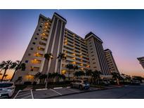 Modern condominium building shows multiple stories of balconies and parking area with tropical landscaping at 4550 Cove Cir # 502, St Petersburg, FL 33708