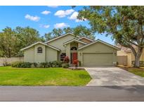 Charming single-story home featuring a well-maintained lawn, mature trees, and an attached two-car garage at 5269 White Sand Ne Cir, St Petersburg, FL 33703