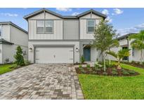 Two-story home with white and gray accents, well-kept lawn, and a two-car garage at 10418 Cross River Trl, Parrish, FL 34219