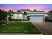 Charming one-story home with a well-maintained lawn, red brick driveway and pleasing blue exterior paint at 19629 Fort King Run, Brooksville, FL 34601