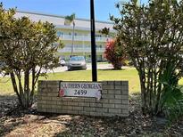 The Southern Georgian community sign stands in front of a light-yellow condo with well-maintained landscaping at 2459 Columbia Dr # 17, Clearwater, FL 33763