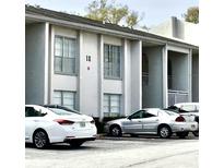 Exterior view of the condo building featuring covered entries and ample parking at 2625 State Road 590 # 1822, Clearwater, FL 33759