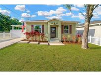 Charming home with vibrant landscaping, American flag, and a well-maintained lawn at 3002 E 24Th Ave, Tampa, FL 33605