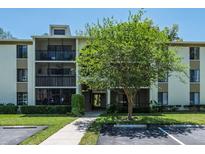 Low-rise condominium building with well-maintained landscaping, parking, and walkway to the entrance at 3166 Lake Pine S Way # E3, Tarpon Springs, FL 34688