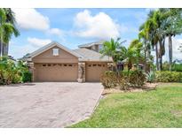 Charming home with a three-car garage, complemented by lush landscaping and a paver driveway at 4111 70Th E Ave, Ellenton, FL 34222