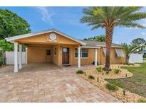 Charming single Gathering home features a brick driveway, covered front porch, and well-manicured landscaping at 4815 Plantation Dr, Tampa, FL 33615