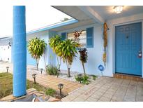 Inviting covered porch with tiled walkway and a well manicured garden at 6800 William Tell Dr, New Port Richey, FL 34653