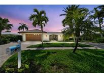 Beautiful waterfront home with a well-maintained lawn and lush landscaping, showcasing curb appeal and serene outdoor living at 854 Harbor Is, Clearwater, FL 33767