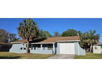 Charming single-story home featuring an attached garage and welcoming front porch at 1007 Greenleaf Way, Tarpon Springs, FL 34689