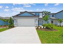 Charming two-story home featuring a spacious driveway, well-maintained lawn, and beautiful landscaping at 10520 Hidden Banks Gln, Parrish, FL 34219