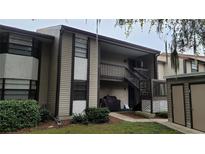 Two-story condo featuring covered entry, brown wood accents, and well maintained landscaping at 12041 Environmental Dr # 6, New Port Richey, FL 34654