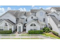 Charming townhome with light gray facade, well-manicured landscaping, and a white picket fence for added curb appeal at 12233 Armenia Gables Cir # 12233, Tampa, FL 33612