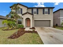 Inviting two-story home features a tidy front yard, cozy entrance, and convenient two-car garage at 16685 Parker River St, Wimauma, FL 33598