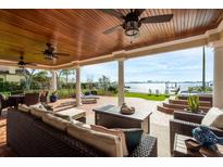 Covered patio showcasing stylish seating, wood ceiling, and serene waterfront views with an outdoor living space at 1748 Sunset Dr, Clearwater, FL 33755