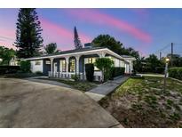 Charming single-story home boasts unique architectural details, and colorful evening sky at 1902 W Nassau St, Tampa, FL 33607