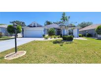 Charming single-story home boasts a well-manicured lawn, front-entry garage, and delightful landscaping at 2113 E Del Webb Blvd, Sun City Center, FL 33573