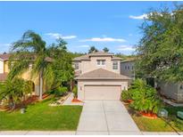 Inviting two-story home with well-manicured lawn and lush landscaping, offering great curb appeal at 3434 Tarbolton Way, Land O Lakes, FL 34638