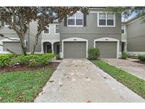 Charming townhome showcasing a two-car garage, meticulously landscaped yard, and inviting facade at 4921 Barnstead Dr, Riverview, FL 33578