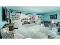 Spacious living room with sliding barn doors and coastal decor, offering a relaxing atmosphere at 5575 Gulf Blvd # 421, St Pete Beach, FL 33706