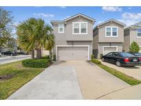 Charming two-story home with a two-car garage, lush landscaping, and a long driveway at 5833 Grand Sonata Ave, Lutz, FL 33558