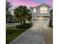 Two story home with a two car garage, palm tree, and beautiful landscaping at 5833 Grand Sonata Ave, Lutz, FL 33558
