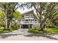Inviting two-story home with a modern design, surrounded by mature trees and lush landscaping at 12893 Poinsettia Ave, Seminole, FL 33776