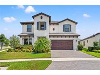 Stunning two-story home with a well-manicured lawn and beautiful landscaping at 13102 Foxtail Fern Dr, Riverview, FL 33579